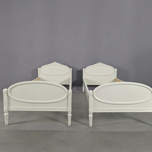 Šviesi viengulė lova su raižytais ornamentais