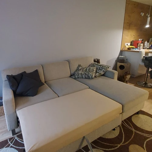 Patogi ištiestinė sofa su trimis pagalvėmis ir stalčiumi