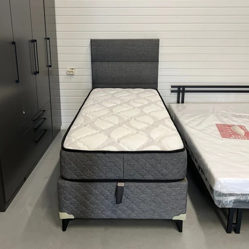 Stilinga viengulė lova su aukštu galvūgaliu ir erdvia dėže